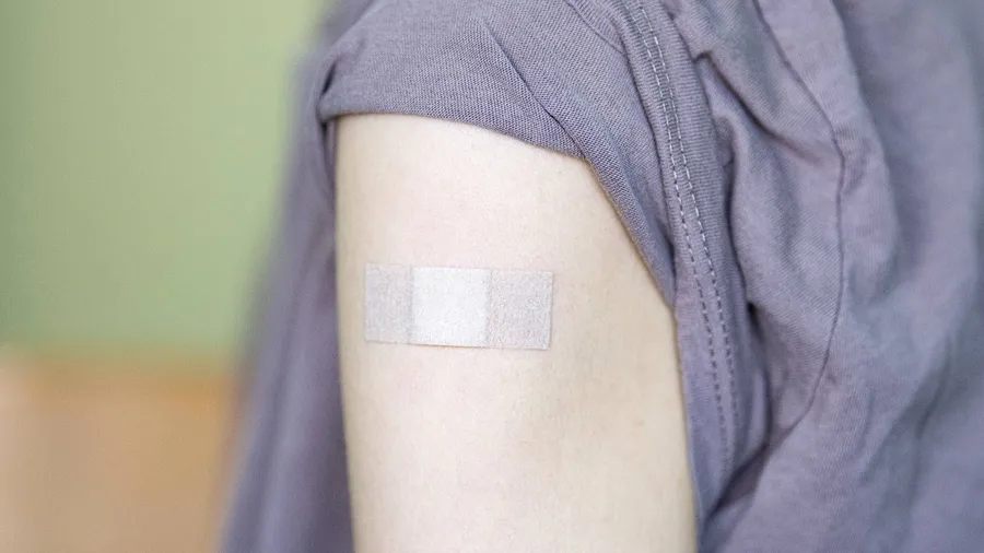 Im Kampf gegen das Virus: Auf dem Arm einer jungen Frau klebt ein Pflaster, nachdem sie geimpft worden ist (Symbolbild).