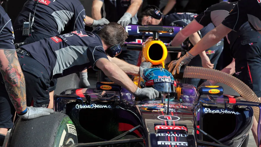 Weltmeister Vettel in seinem Red Bull: es braucht viele fleißige Hände, um den Wagen voran zu bringen