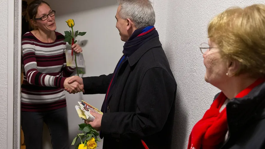 Rosenkavalier: Peter Feldmann überreicht Alberta Martinez eine Rose, Margot Grana (rechts) begleitet den Oberbürgermeister beim Wahlkampf in Fechenheim.