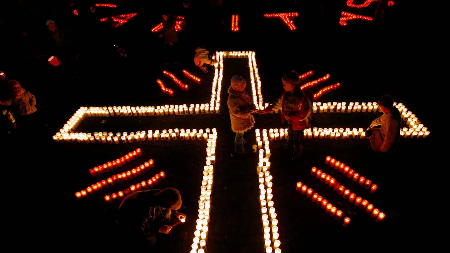 Licht und Schatten: das Caritas-Kreuz im Kerzenschein