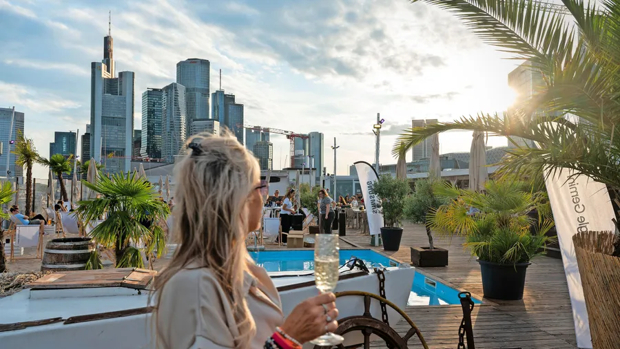 Auf das Leben: Mit einem kühlen Getränk in der Hand und dem Ausblick auf die Frankfurter Skyline lassen sich Sommerabende in der Metropole genießen.