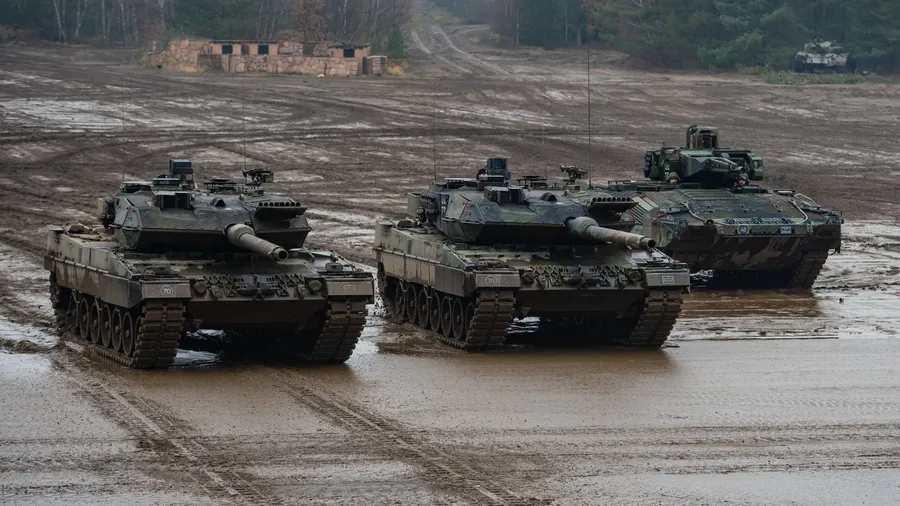 Zwei Kampfpanzer (v.l.) der Bundeswehr vom Typ Leopard 2A6 und ein Schützenpanzer vom Typ Puma fahren bei einer Übung durchs Gelände.
