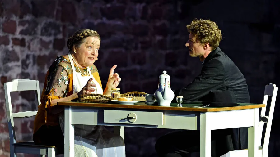 „Der Prozess“: Marianne Sägebrecht als Haushälterin Gruber steht als Einzige dem verhafteten Josef K., dargestellt von Ronny Miersch, seelisch bei.