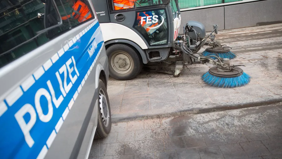 Großreinemachen: Eine Kehrmaschine säubert den Gehweg vor dem 1. Polizeirevier nahe der Konstablerwache, wo mehrere Autos in Brand gesteckt worden waren.