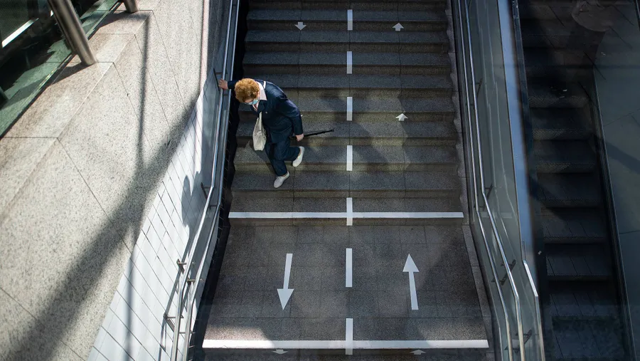 Mit Abstand und festgelegten Verkehrsrichtungen durch den Corona-Alltag: Eine ältere Frau steigt in Hamburg die Treppen einer U-Bahn-Station hinab. Das Leben in der Pandemie stellt für viele Menschen auch psychologisch eine Herausforderung dar.