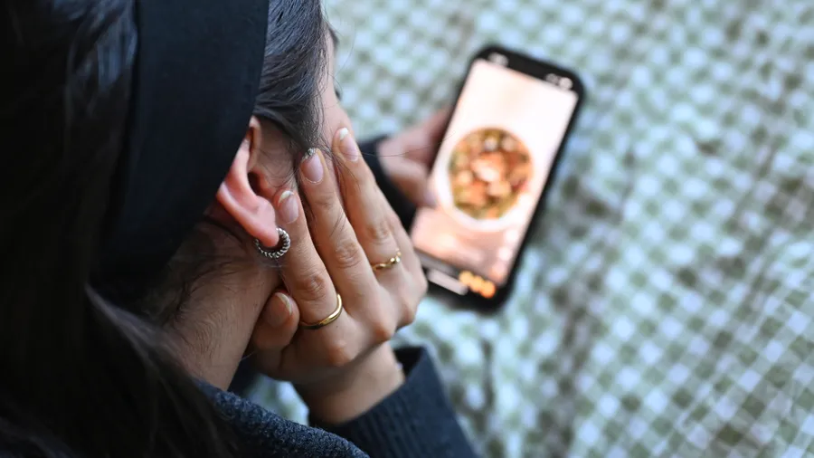 Junge Frau mit Handy: Tiktok wird vor allem von Kindern und Jugendlichen benutzt