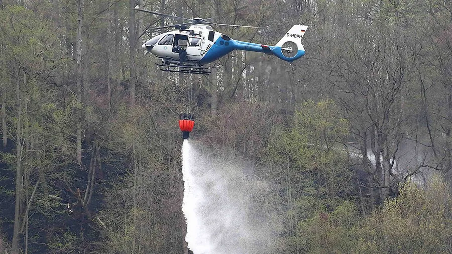 Hubschrauber, hier ein Modell der Polizei, beim Löscheinsatz an der Bleilochtalsperre, wo Einsatzkräfte seit Ostern einen Großbrand bekämpfen.