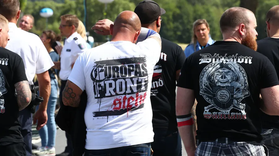 Besucher stehen vor dem Veranstaltungsgelände beim Rechtsrock-Festival in Themar, Thüringen.