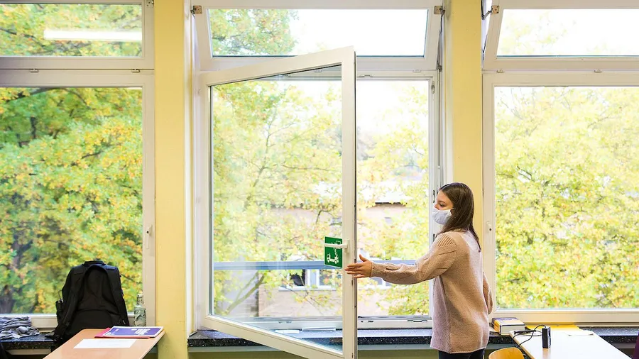 Gut geschützt gegen Corona: Eine Schülerin lüftet den Klassenraum.
