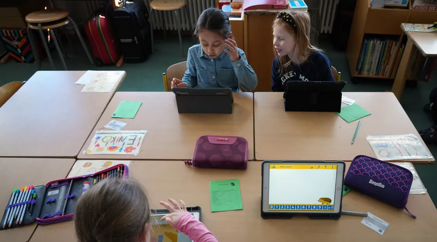 Schülerinnen der Berliner Hunsrück-Grundschule lösen im Mathematik-Unterricht am Tablet eine Rechenaufgabe.
