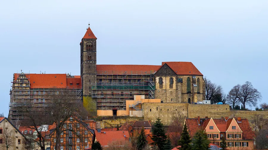 Der Schlossberg in Quedlinburg mit dem von Baugerüsten eingeschaltem Schloss und, rechts, der Stiftskirche Sankt Servatii