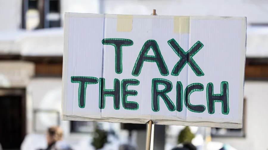 Auf einem Schild bei einer Demonstration in Davos steht „Tax the rich“.