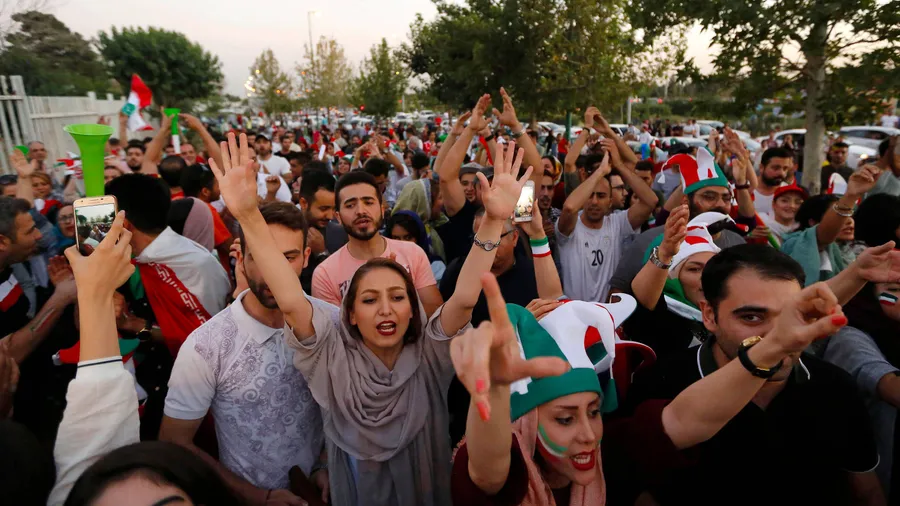 Mussten zunächst gemeinsam vor dem Stadion ausharren, dann ging es zusammen zum Public Viewing: iranische Männer und Frauen jubeln ihrem Team bei der WM zu.