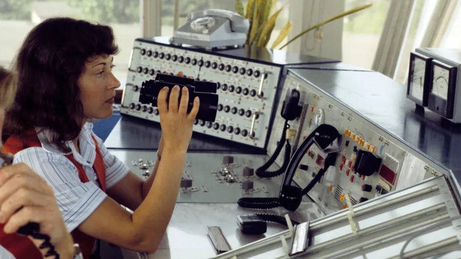 Technisch qualifizierte Verantwortung bietet Gelegenheit für neue Formen weiblicher Eleganz: Eine Fluglotsin bei der Arbeit in einem Tower der Interflug, 1980.