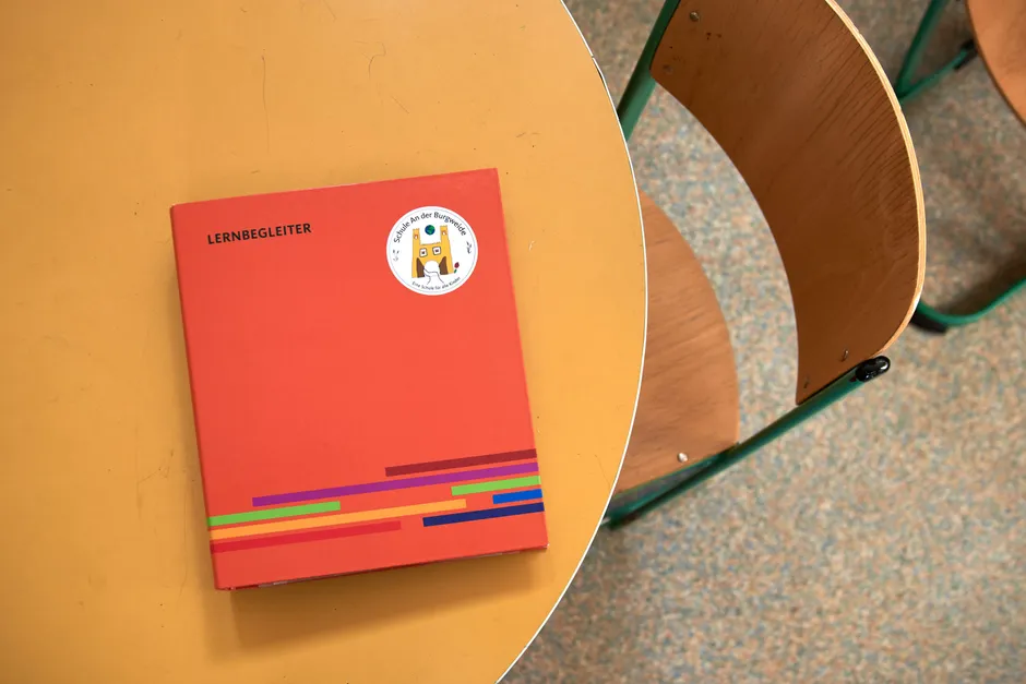 Der „Lernbegleiter“ ist ein von der Burgweide-Schule entwickelter Ordner, in dem Ziele für die Hauptfächer Deutsch, Englisch und Mathematik als Aufkleber zur Auswahl stehen. Während der Lernbüro-Zeiten arbeiten die Kinder eigenständig an ihren Zielen.