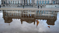 Der Reichstag spiegelt sich in Pfützen auf dem Platz der Republik.