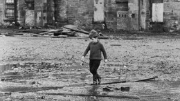 Alan Parks’ Glasgow der Siebziger: Ein Junge spielt in einem verfallenen Gelände in einer Pfütze.