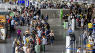 Passagiere warten am Frankfurter Flughafen auf ihren Check-In (25. Juli).