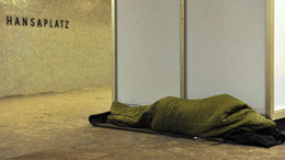Ein Obdachloser liegt auf dem Boden der Berliner U-Bahnstation Hansaplatz.