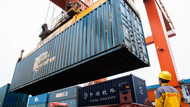 Viel Fallhöhe: Chinesische Arbeiter verladen Container an einem Umschlagsbahnhof. Viel Fallhöhe: Chinesische Arbeiter verladen Container an einem Umschlagsbahnhof.