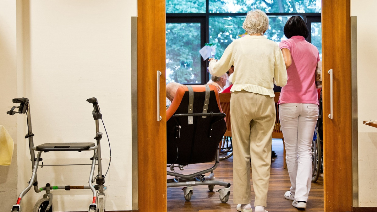 Eine Pflegerin begleitet eine Frau in einer Klinik in Fürth. - dpa