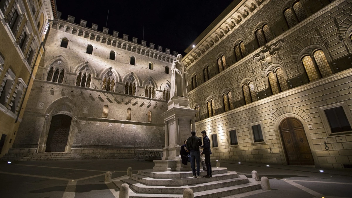 Menschen unterhalten sich am Sallustio Bandini-Monument vor der Zentrale der italienischen Krisenbank Monte dei Paschi di Siena. - dpa