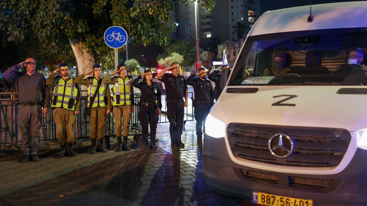Israelische Soldaten salutieren vor dem Konvoi, der eine vermutlich tote Geisel aus dem Gazastreifen nach Tel Aviv bringt. - EPA
