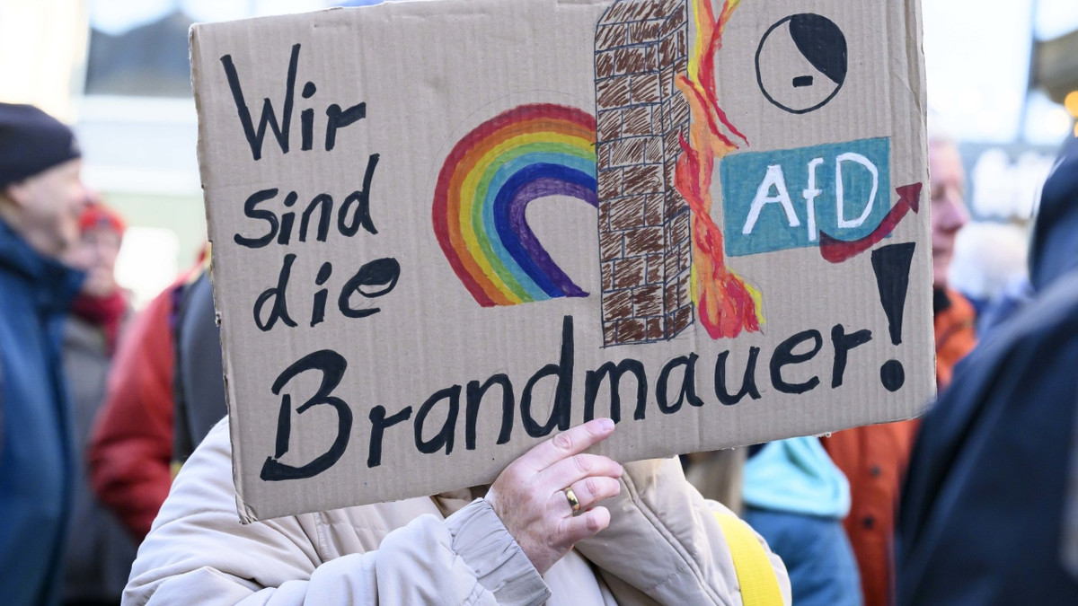 „Wir sind die Brandmauer“ steht auf dem Schild dieser Demonstrantin bei einer Kundgebung gegen die AfD. - dpa