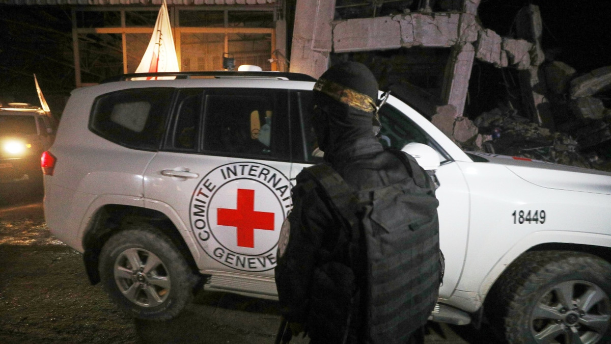 Ein bewaffneter Mann in der Uniform der Qassam-Brigaden, dem militärischen Flügel der Hamas, steht Wache, als Fahrzeuge des Roten Kreuzes am 14.10. ein Lagerhaus verlassen. - dpa