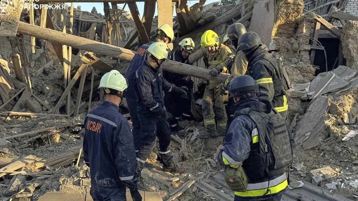 Rettungskräfte in den Trümmern: Nach dem Angriff auf Saporischschja am Montagmorgen - dpa