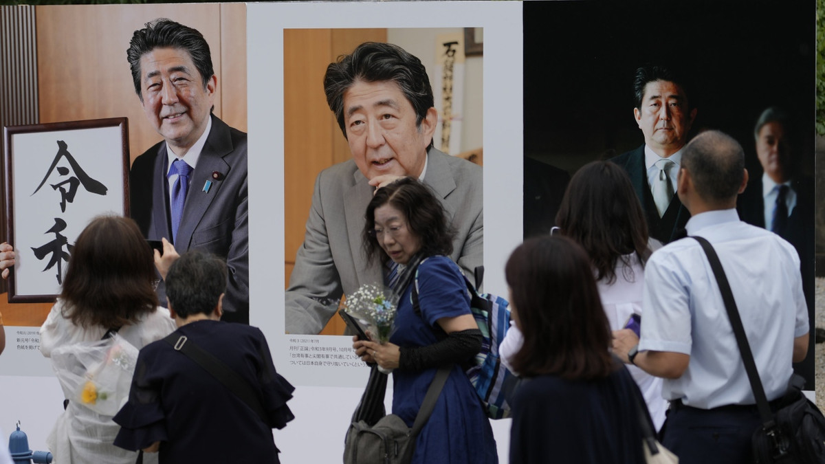 Menschen betrachten im Juli 2023 Fotos des ehemaligen japanischen Premierministers Shinzo Abe. Er wurde am 8. Juli 2022 auf einer Wahlkampfveranstaltung erschossen. - dpa