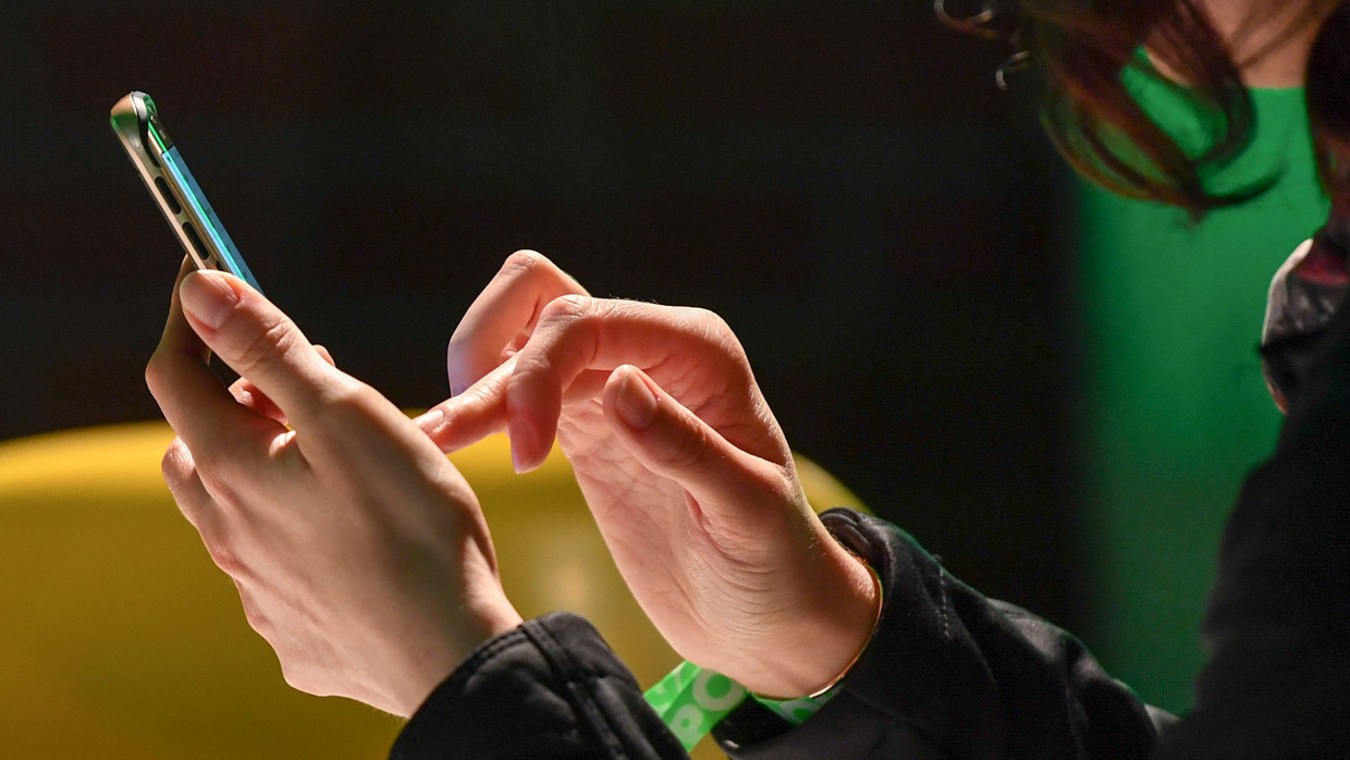  Eine Frau tippt auf ihrem Handy.