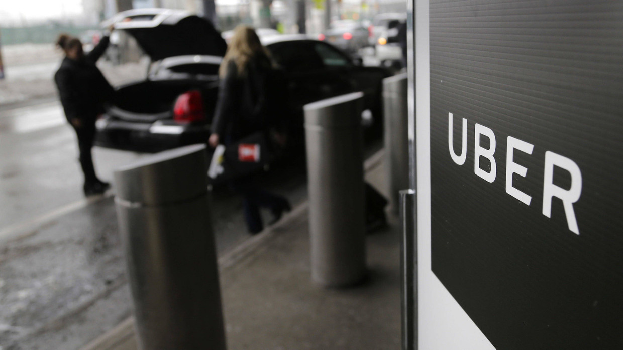 Ein Schild mit dem Logo des amerikanischen Dienstleistungsunternehmens Uber am Abholpunkt von Uber auf dem LaGuardia-Flughafen in New York Ein Schild mit dem Logo des amerikanischen Dienstleistungsunternehmens Uber am Abholpunkt von Uber auf dem LaGuardia-Flughafen in New York