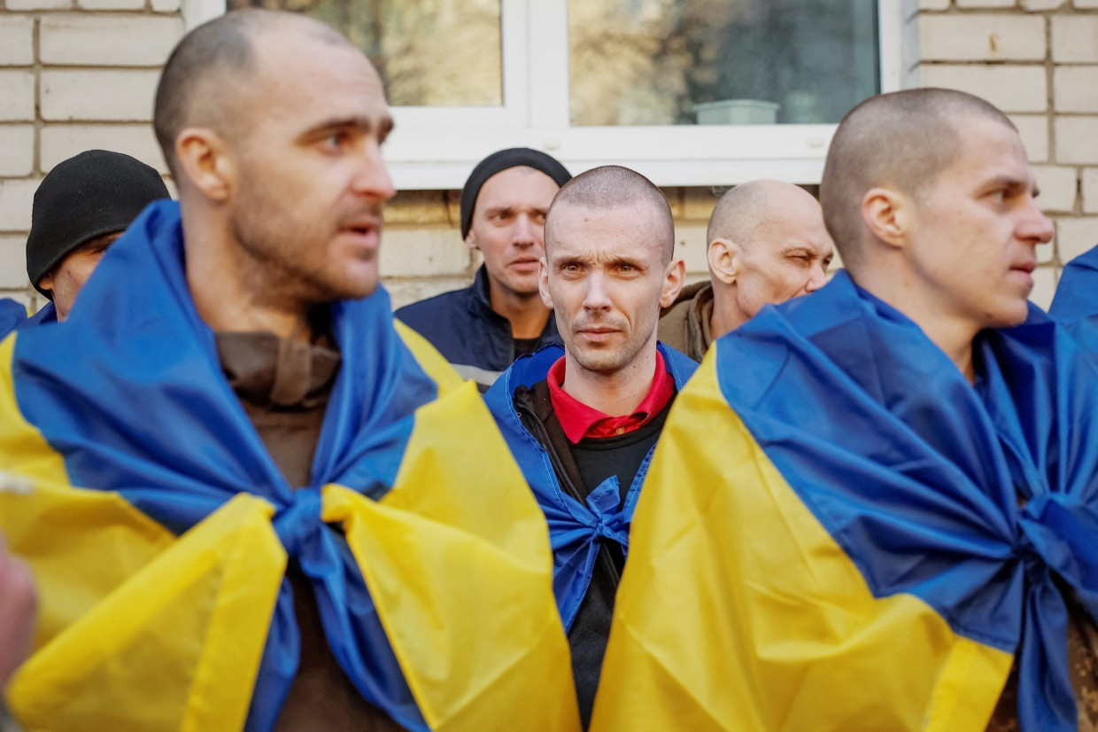 Ukrainische Kriegsgefangene sind nach einem Gefangenenaustausch Mitte März in ukrainische Fahnen gehüllt.
