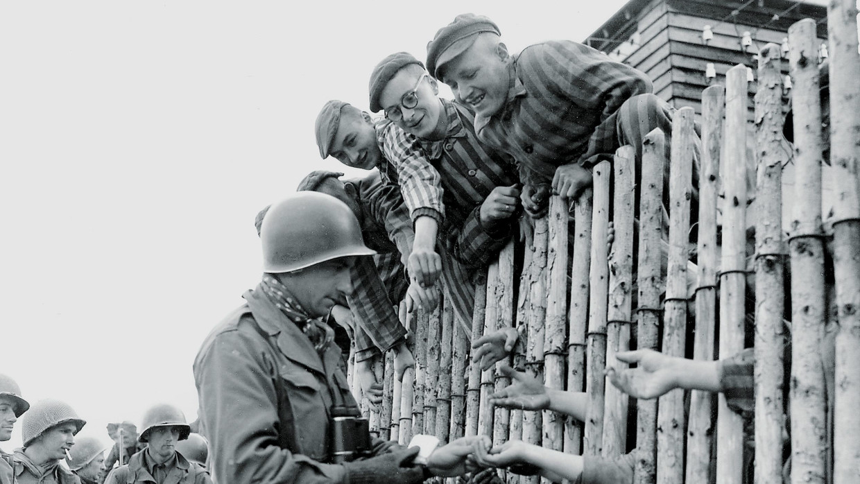 Amerikanische Soldaten und Insassen des Konzentrationslagers Dachau nach der Befreiung am 29. April 1945