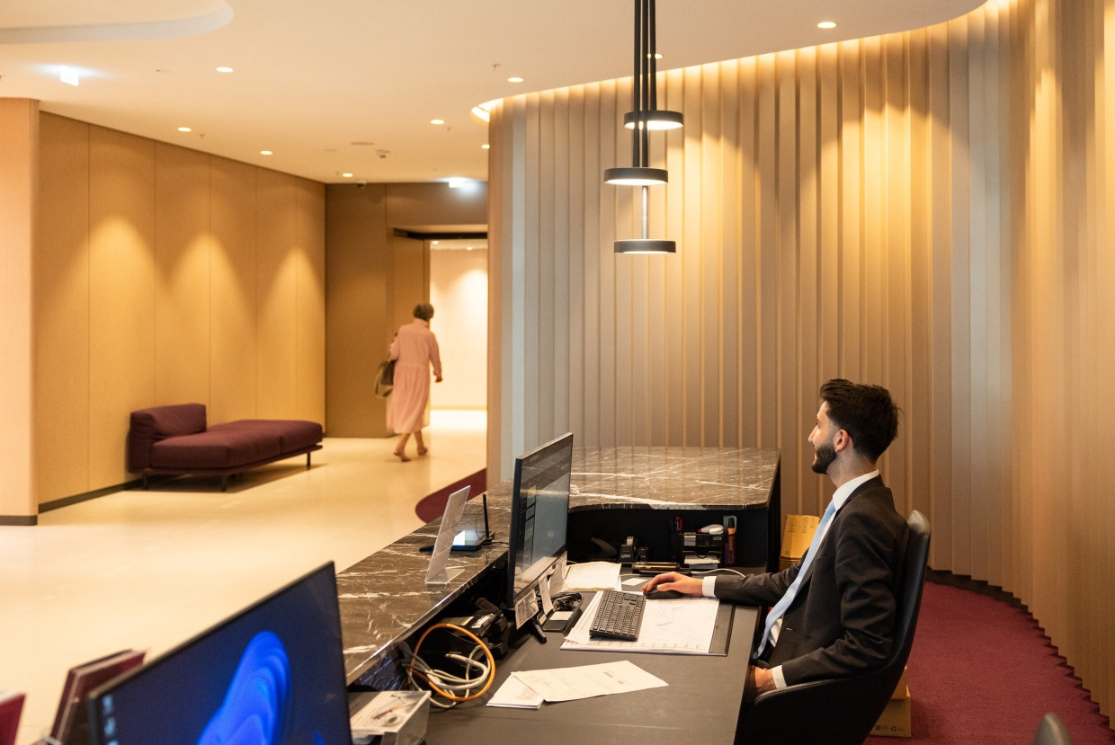Am Tresen im Foyer hat Concierge Leonardo Boates im Blick, wer den Wohnturm betritt.
