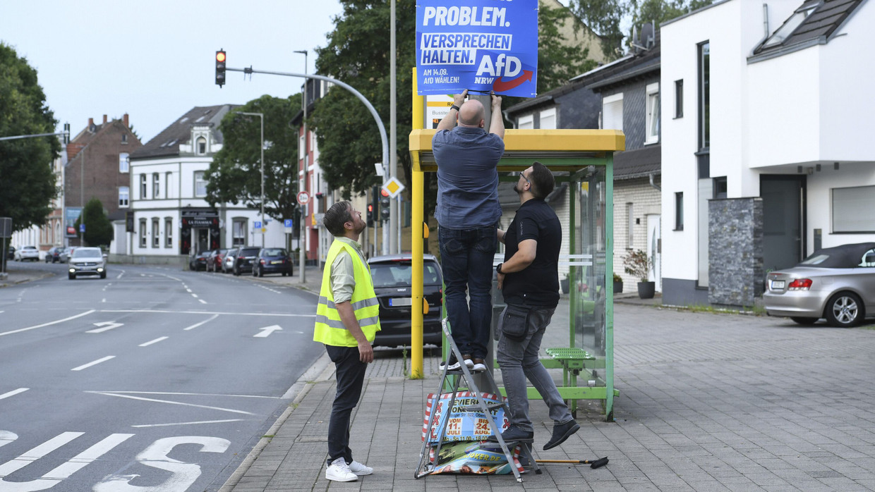 Wahlkampfhelfer der AfD montieren in Oberhausen in Plakat zur Kommunalwahl.
