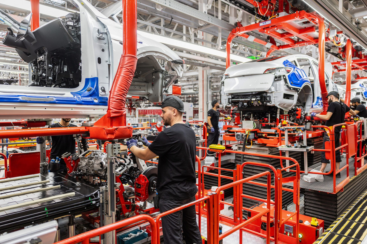 Mitarbeiter in einer Produktionslinie der Tesla Gigafactory in Grünheide arbeiten an Autos des Typs Model Y.