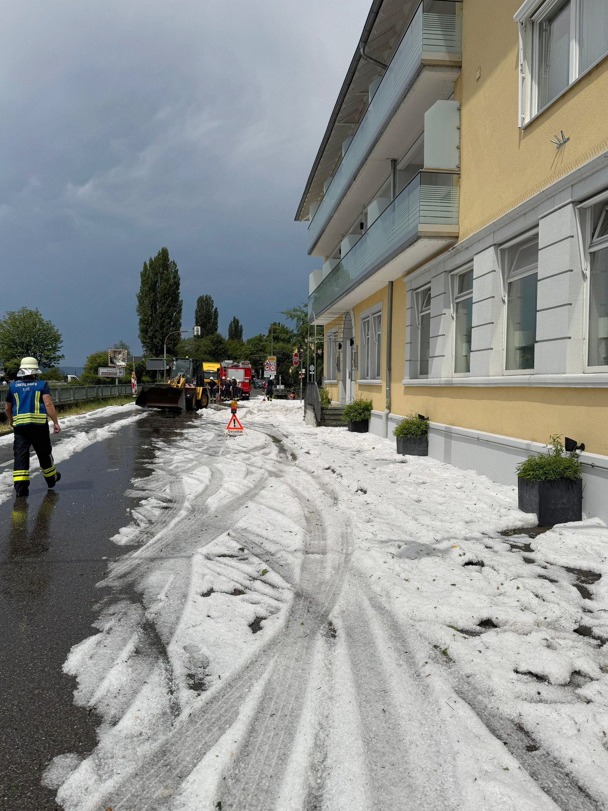 Einsatzkräfte räumen nach dem Unwetter in Sipplingen die Straße.