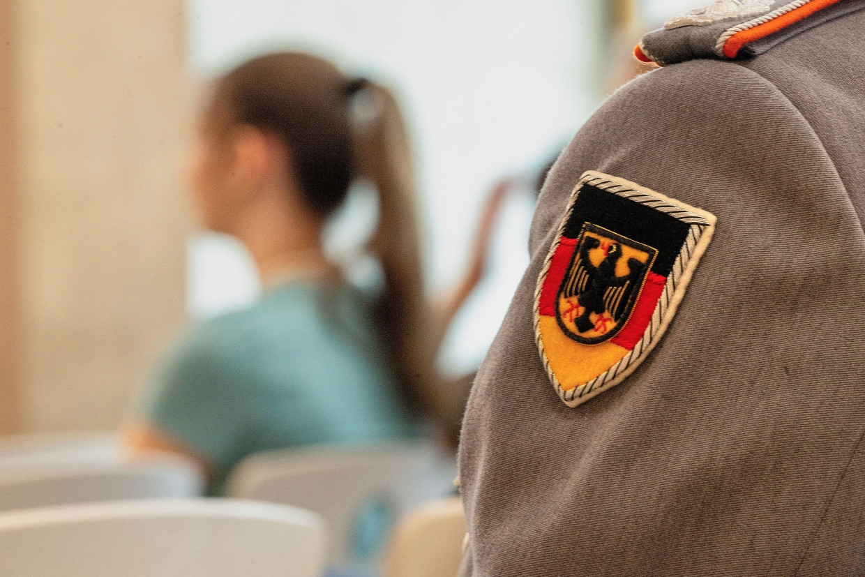 View straight ahead: A Bundeswehr soldier sits in a row in a school classroom.