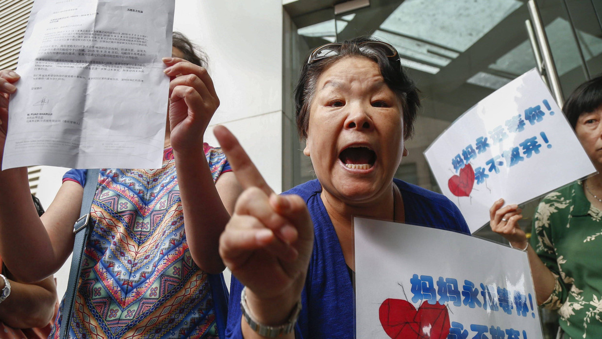 Wütend und verzweifelt: Angehörige von MH370-Opfern protestieren vor dem Büro von Malaysia Airlines in Peking. Wütend und verzweifelt: Angehörige von MH370-Opfern protestieren vor dem Büro von Malaysia Airlines in Peking.