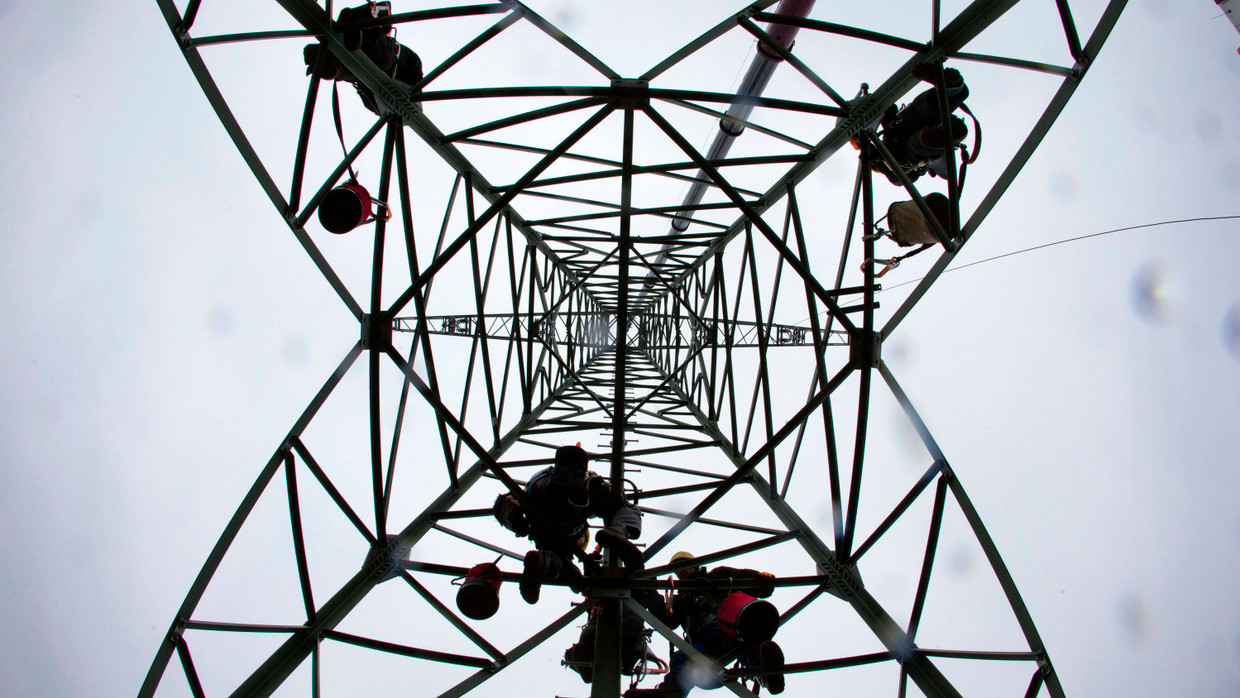 Monteure in einem Metallmast einer 110-Kilovolt-Freileitung zwischen Ludwigslust und Hagenow